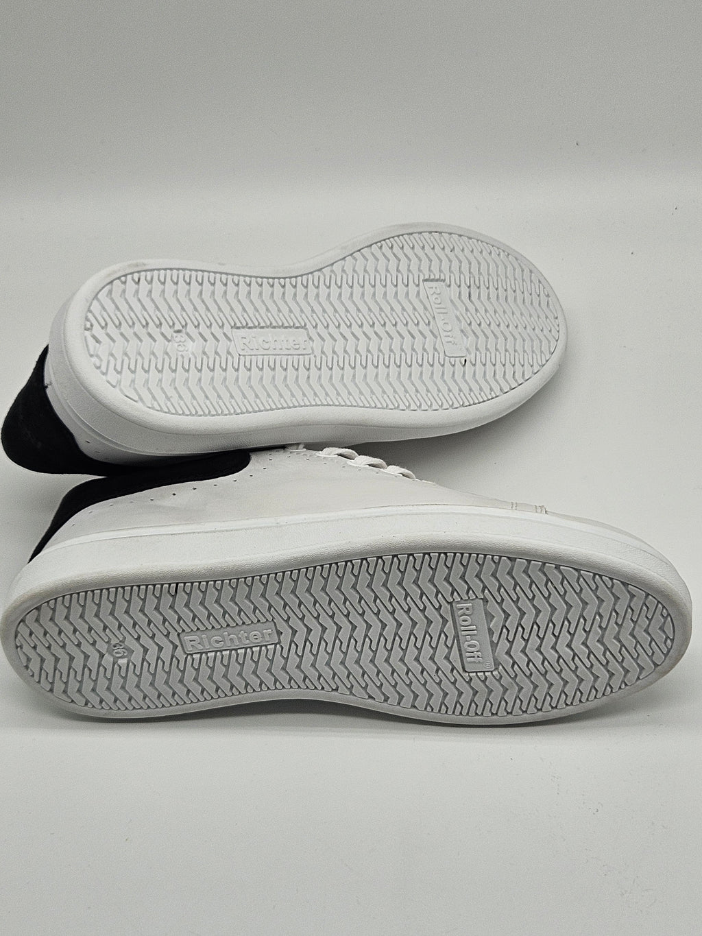 Grauer Richter Alex Sneaker aus Leder mit weißer Sohle, sportliches Design, seitliche Markenlogo, auf glattem Boden.