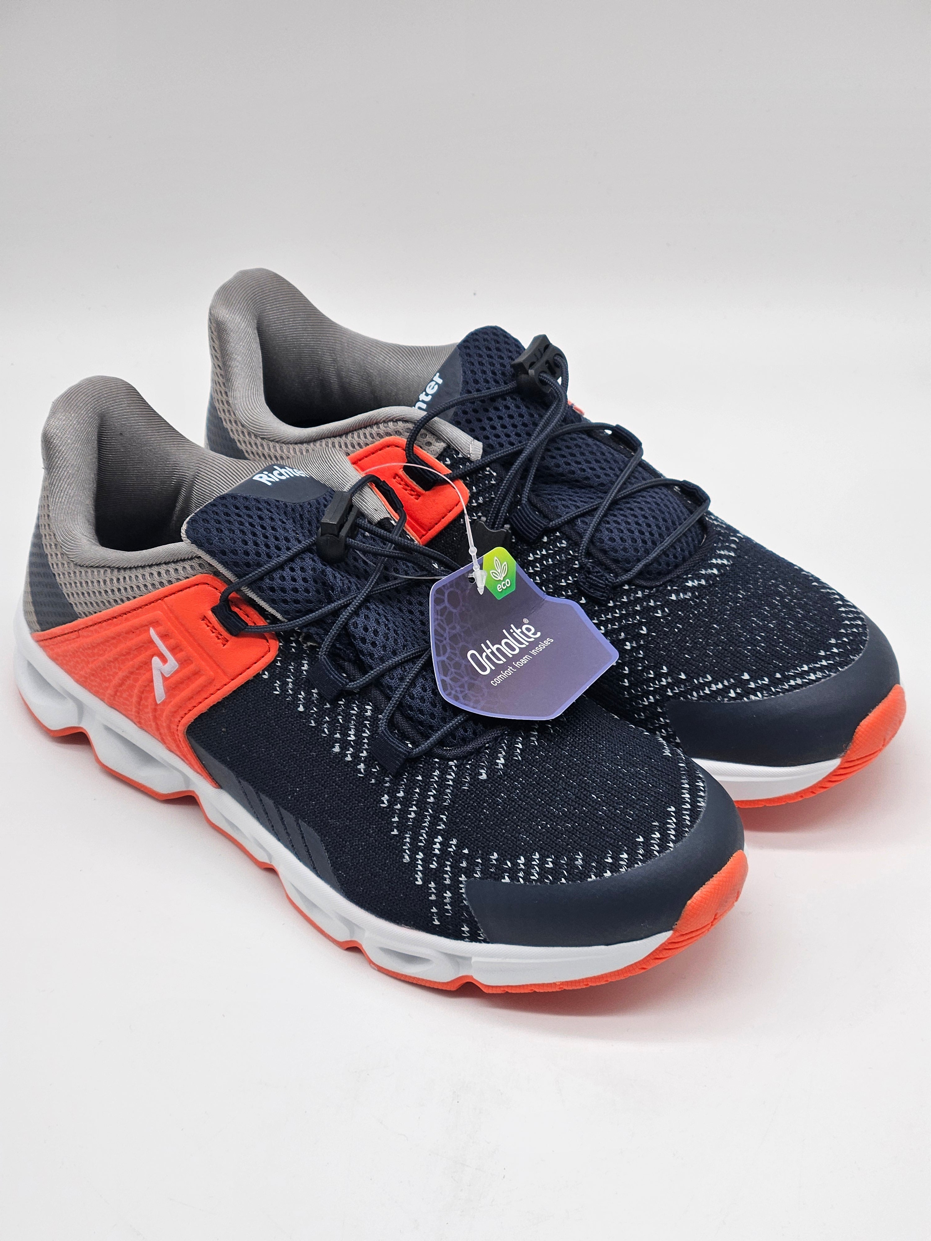 Schuhbild eines schwarzen Richter Sneakers mit weißen Sohlen auf glattem Boden, seitliche Ansicht